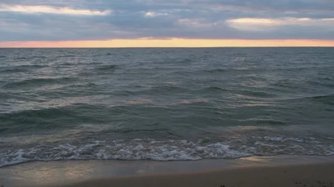 Sea view at sunset with smooth waves and cloudy sky. Stock Footage 308520378