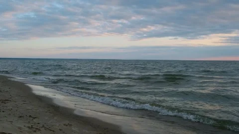 Sea view at sunset with smooth waves and cloudy sky. Stock Footage 309637029