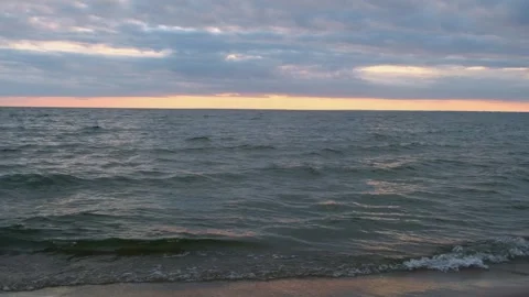 Sea view at sunset with smooth waves and cloudy sky. Stock Footage 312242229