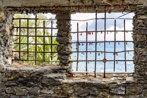 Sea view through rusty iron grate window with love locks in Cinque Terre, Ita Stockfoto's