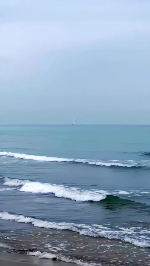 Sea view with waves on day and in distance sailboat. Stock Footage 233317474
