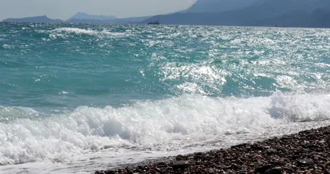 Sea view. Waves run over the rocky pebble beach Stock Footage 153792203