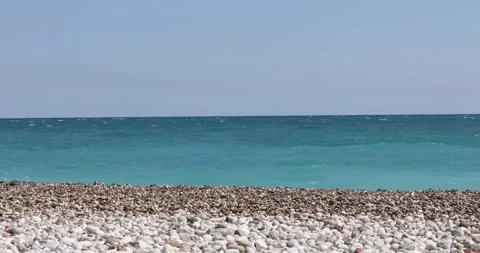 Sea view. Waves run over the rocky pebble beach Stock Footage 153792425