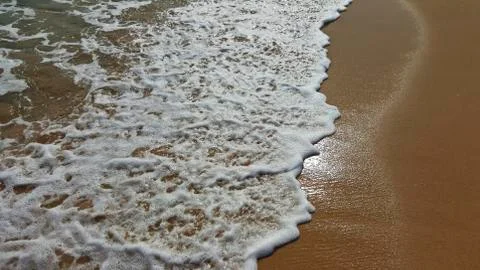 Sea water covers the sandy beach Stock Photos