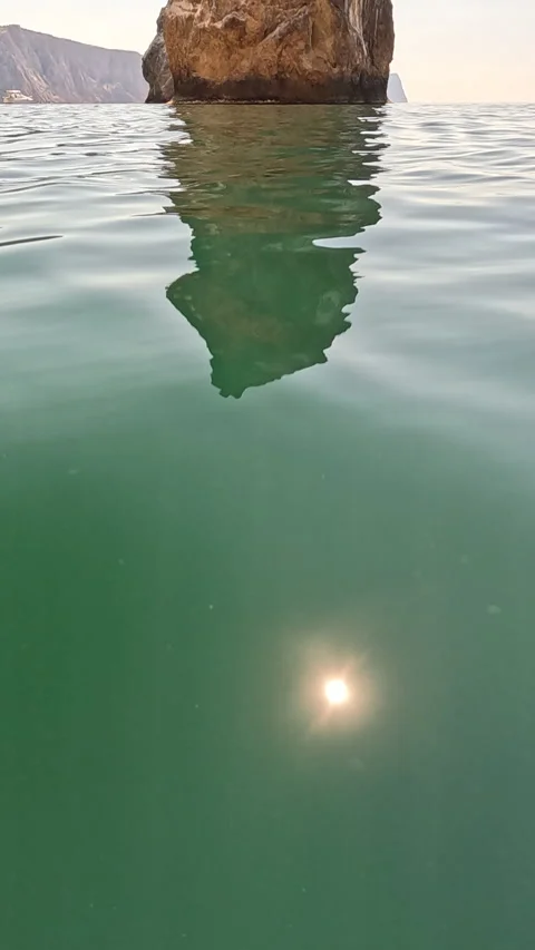 Sea water rock, split view showing rock formation above and its reflection below Stock Footage 315942606