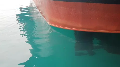 Sea water splashing on the lower back hull of a moving tugboat. Stock Footage 346579313