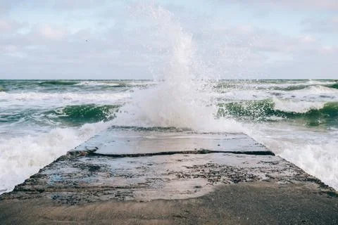 Sea wave breaking on the pier Stock Photos