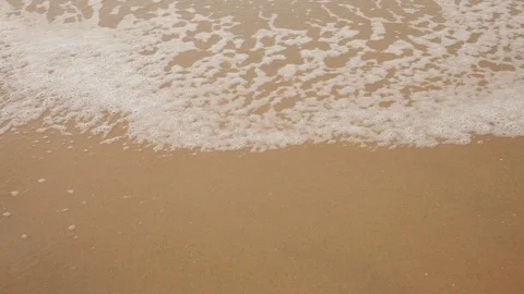 Sea Wave covers the sandy beach Stock Footage 122988215