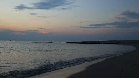 Sea wave hit the shore with the passing boat. Landscape of sunrise view. Stock Footage 116767161