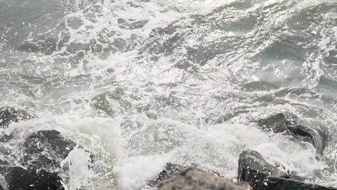 Sea wave hitting rocks beach summer stone evening sunset above view slow motion Stock Footage 107877279