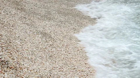 Sea wave rolled ashore covered with shells . Stock Footage 49625851