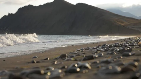 A sea wave rolls ashore at sunset Stock Footage 121719548