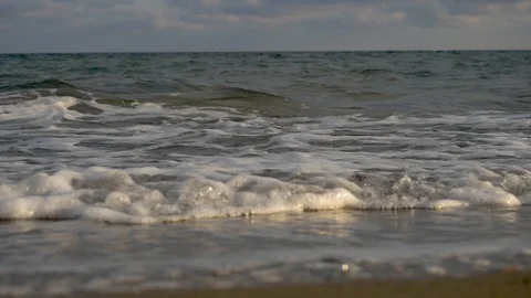 A sea wave rolls ashore at sunset Stock Footage 121719696