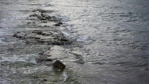Sea wave rolls over a stone reef in slow motion Stock Footage 146681073
