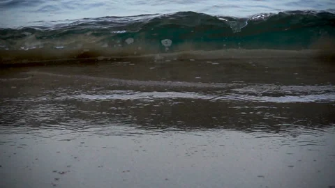 Sea wave rolls onto a sandy beach in slow motion Stock Footage 130491941