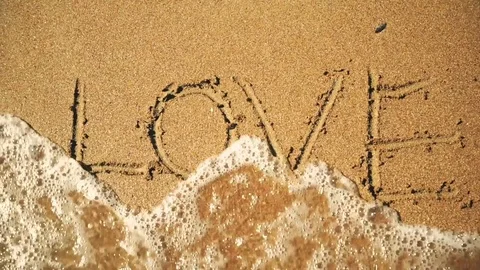 Sea Wave Washes Away The Drawing Of A Love On Sand Video stock 78612257