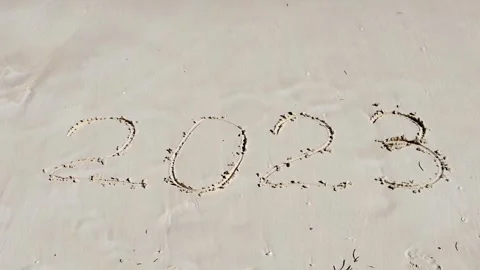 A sea wave washes away the sand next to the inscription 2023.Vacation in 2023 Stock Footage 243301313