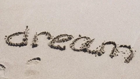 A sea wave washes away the text written on the sand from the beach - dream Video stock 255947006