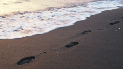 Sea wave washes away the traces on the sand at sunset Vidéo 123710099