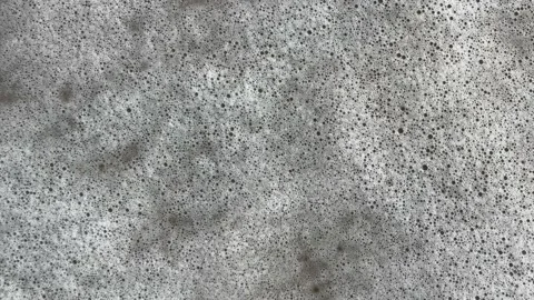 Sea wave washes away two footprints steps on the sand, vertical footage. Stock-Footage 229569933