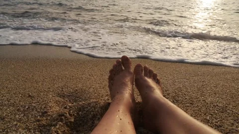 Sea wave washes over a sandy beach in the golden light of a setting sun Stock Footage 301603080