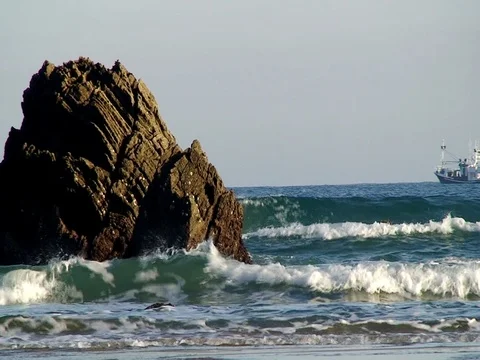 Sea waves against rocks and ship in the distance Video stock 80425190