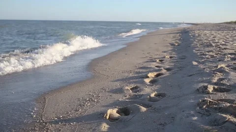 Sea waves and deep human footprints at wet sand Stock Footage 151899871