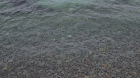 Sea waves and a pebble beach in winter. Cloudy weather and calm sea Stock Footage 148188892