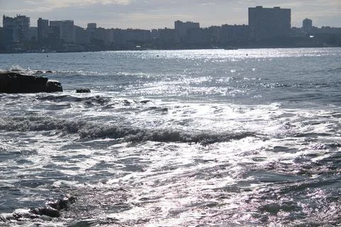 Sea with waves and the reflection of the sun on the water Stock Photos