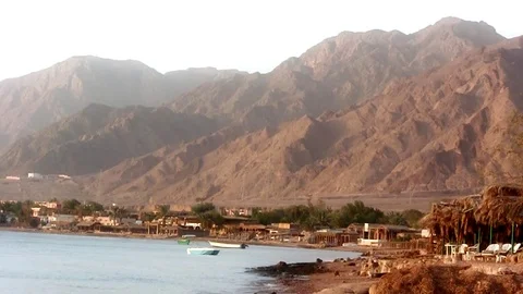 Sea waves and shore side view with a few boats and Sinai mountains Stock Footage 71933004