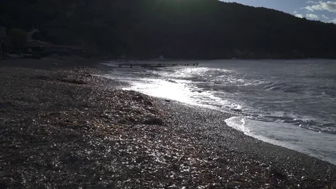 Sea waves in backlight on shingle beach 스톡 동영상 84653651