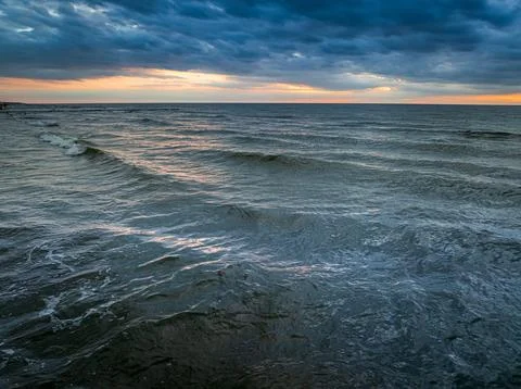 Sea waves backlit by a vibrant sunset in Poland. Stock Photos