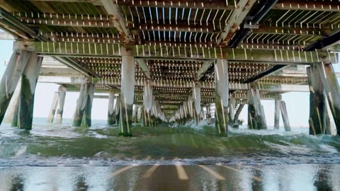 Sea waves on the beach under the pier. Slow motion Stock Footage 158515659
