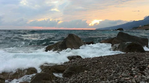 Sea waves break about big stones ashore at sunrise Stock Footage 43201044
