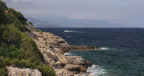 Sea waves break about the rocky coas, the cape Ferrat of South France Stock Footage 130796314