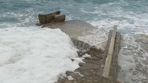 Sea waves break on the stone pier. Slow motion Stock Footage 84130302