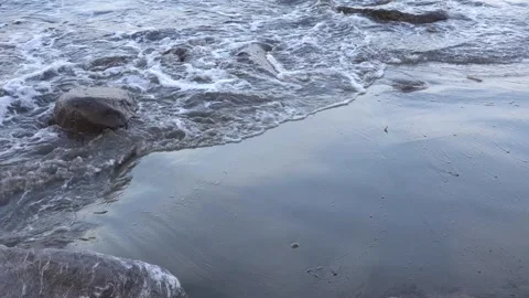 Sea waves breaking and crashing at a rocky beach during sunset or sunrise. Stock Footage 296796156