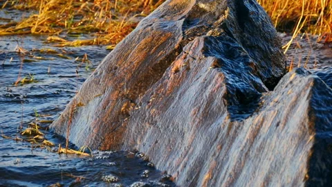 Sea waves breaking on a granite boulder Stock Footage 231410727