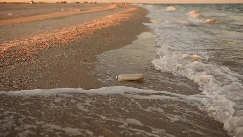 Sea waves brought waste plastic trash to the sandy coast Stock Footage 143286083
