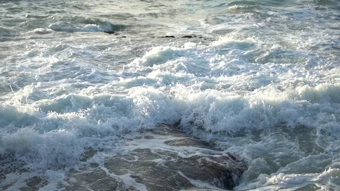 Sea Waves Crash On Beach Sand and rocks Forming white Foam Stock Footage 99164378