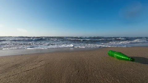 Sea waves crash into the camera. Green plastic container thrown into the sea Stock Footage 276711682