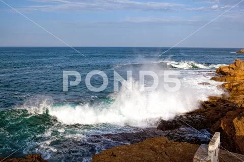 Sea waves crashing against the rocks . Stock Photos