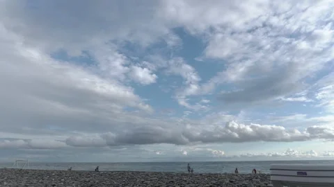 Sea waves crashing on pebble beach under bright sky with clouds Stock Footage 336180230