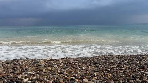 Sea waves crashing on pebble beach under dark stormy sky horizontal video frame Stock-Footage 343945309
