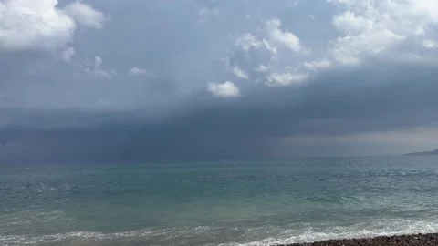 Sea waves crashing on pebble beach under dark stormy sky horizontal video frame Vídeos de archivo 343945355