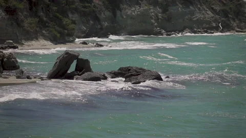 Sea waves crashing on rocks on an empty beach Stock Footage 131395601