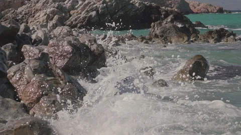 Sea waves crashing on rocks on an empty beach Stock Footage 132221925