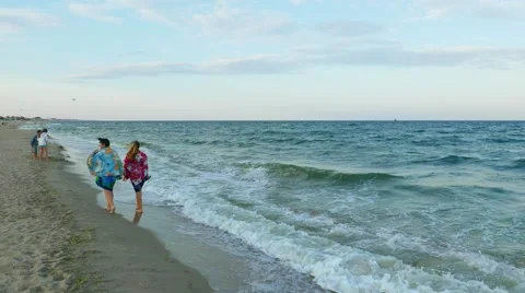 Sea waves on a deserted sandy beach with vacationers  Stock Footage 54221316