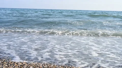 Sea waves with foam and an empty pebble beach. Wave breaking on beach Stock Footage 160886126