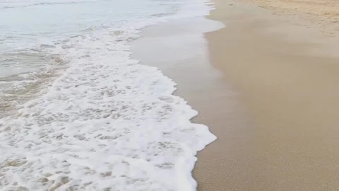Sea waves with foam run to an empty sandy beach Stock Footage 153998496
